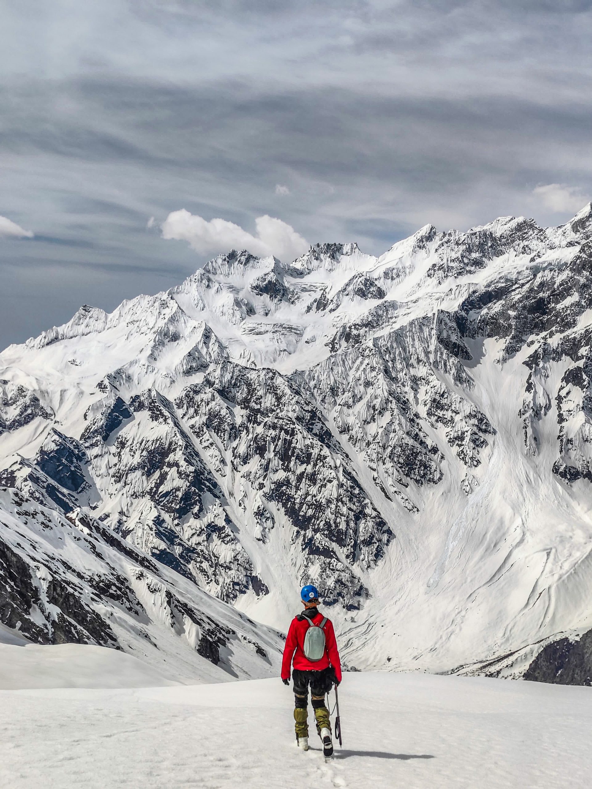 Alpinista caminando hacia la cordillera nevada del Himalaya indio